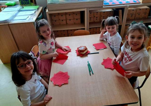 Dziewczynki przy stole w czasie zabawy plastycznej pt. "Pączek"