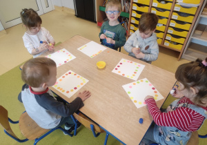 Dzieci przyozdabiają papierowe talerzyki.