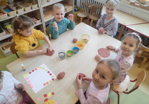 Dzieci modelują kształt pączków z masy solnej.