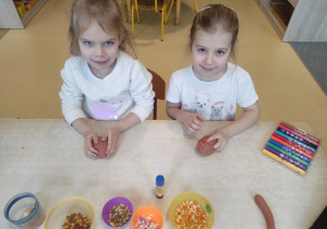 Dziewczynki lepią pączki z masy solnej.