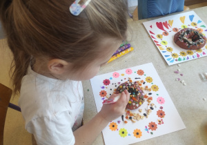 Dziewczynka dekoruje pączki.