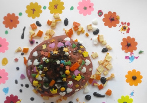 Prezentacja pączka na kolorowym talerzyku.