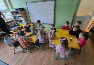 Dzieci podczas warsztatów badają strukturę mleka kokosowego