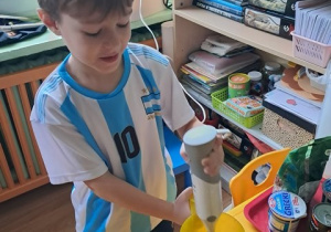 Chłopiec miksuje mrożone truskawki