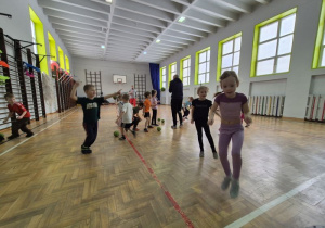 Dzieci biegają oraz wykonują rzut piłką