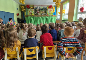 Dzieci siedzą na widowni, oglądają teatrzyk, na scenie tańczy słonik pacynka