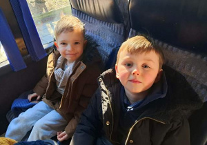 Chłopcy siedzą w autokarze i czekają na wyjazd do "Baśniowej Kawiarenki"