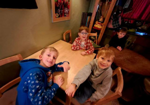 Chłopcy siedzą na krzesełkach i czekają na rozpoczęcie przedstawienia w "Baśniowej Kawiarence"