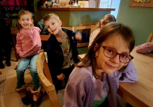 Dzieci siedzą na krzesełkach i czekają na rozpoczęcie przedstawienia pt. "Siedem koźlątek" w "Baśniowej Kawiarence"