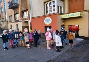 Dzieci stoją w parach przed budynkiem Baśniowej Kawiarenki