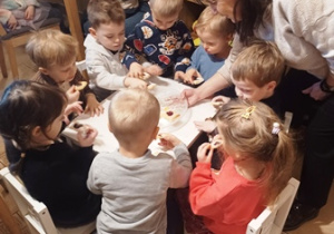 Pani częstuje dzieci ciasteczkami