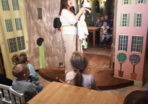 Aktorka prezentuje lalkę wykorzystaną w spektaklu