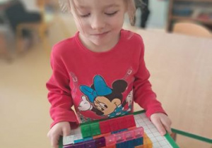 Dziewczynka prezentuje swoją pracę z klocków magnetycznych