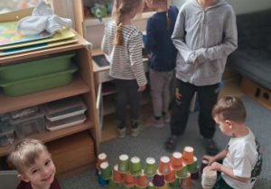 Chłopcy układają wieżę z papierowych kubeczków