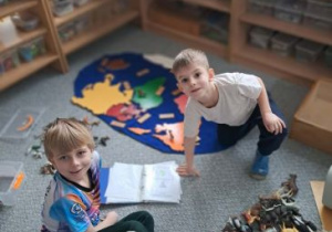 Chłopcy na dywanie układają kontynenty