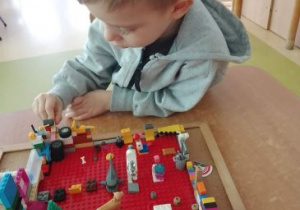 Chłopiec buduje z klocków Lego