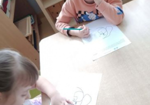 Chłopiec z dziewczynką dorysowują drugą połowę psa