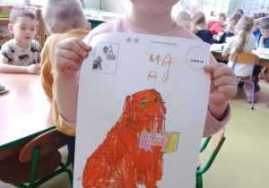 Dziewczynka pozuje do zdjęcia ze swoją kolorowanką