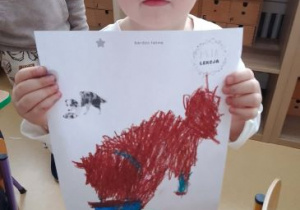 Chłopiec pozuje do zdjęcia z ilustracją przedstawiajacą psa