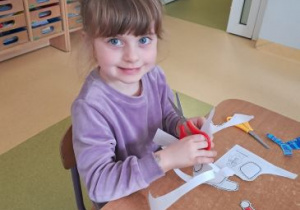 Dzieczynka wycina ilustrację przedstawiającą pingwina