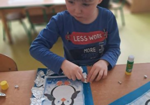 Chłopiec przykleja ramkę z folii aluminiowej