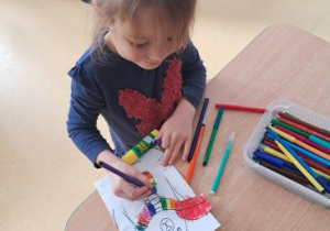 Dziewczynka koloruje szal misia