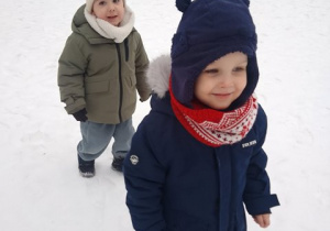 Chłopcy spacerują po ogrodzie przedszkolnym w zimowej aurze