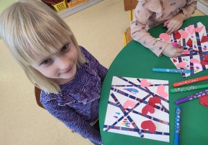 Dziewczynka prezentuje walentynkową pracę.