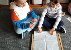 Mikołaj pod okiem Bruna składa serwetkę