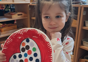 Dziewczynka z pracą plastyczną - Serduszko