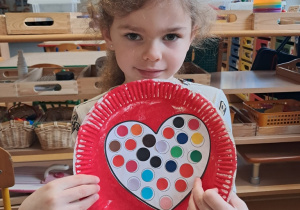 Dziewczynka prezentuje przygotowaną przez siebie walentynkę