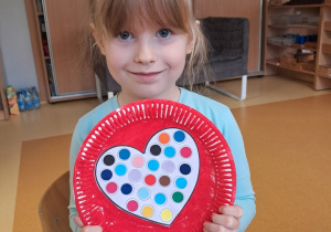 Dziewczynka prezentuje przygotowaną przez siebie walentynkę