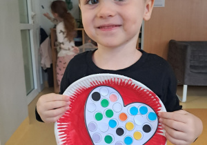 Chłopiec prezentuje przygotowaną przez siebie walentynkę