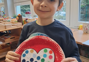 Chłopiec prezentuje przygotowaną przez siebie walentynkę