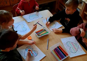 Dzieci przy stoliku podczas wykonywania ćwiczeń grafomotorycznych z motywem walentynkowym