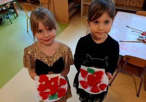 Zosia i Liwia trzymają w dłoniach talerzyki z sercami walentynkowymi zrobionymi z masy solnej