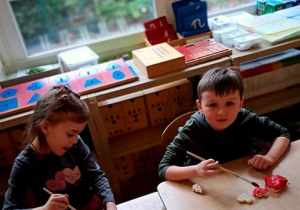 Tosia i Bruno malują czerwoną farbą serca uformowane z masy solnej