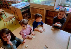 Dzieci przy stoliku podczas ugniatania masy solnej
