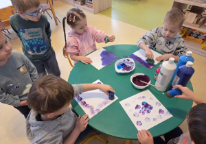Dzieci stemplują tło pracy plastycznej