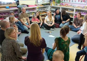 Rodzice siedzą w kółku na dywanie