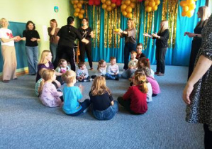 Dzieci w małym kole podają sobie piłkę