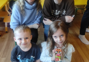 Dzieci ze swoimi rodzicami piją sok.