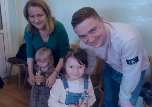 Rodzice z dziećmi pozują do zdjęcia.