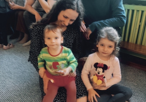 Dzieci pozują do zdjęcia z rodzicami.