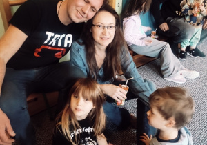 Rodzice wraz z dziećmi pozują do zdjęcia.
