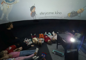 Dzieci leżą w namiocie i czekają na rozpoczęcie seansu