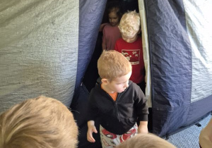 Dzieci wychodzą z namiotu, w którym znajduje się Kino Sferyczne