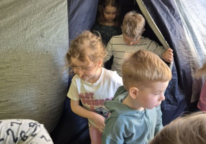 Dzieci wychodzą z namiotu, w którym znajduje się Kino Sferyczne