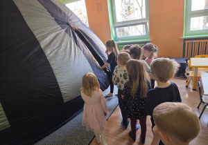 Dzieci wchodzą do namiotu, w którym odbędzie się projekcja filmu