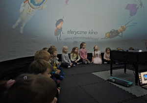 Dzieci siedzą w "Kinie Sferycznym"